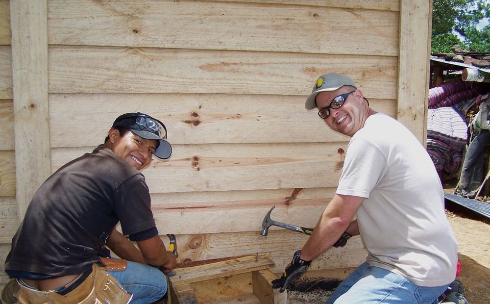 Two builders working together on a timber wall