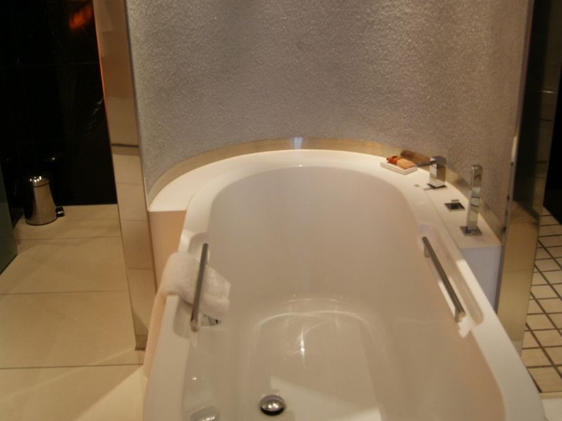 Freestanding white bathtub in a tiled bathroom